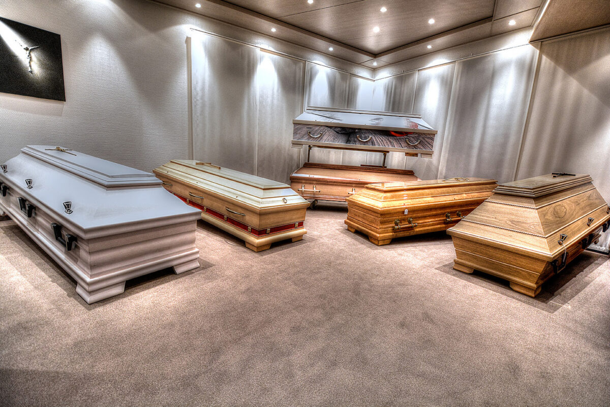 Ausstellungsraum mit mehreren aufgestellten Särgen.